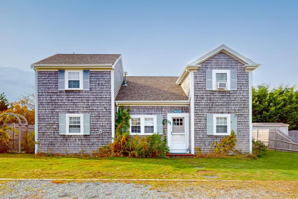 a brick house with white windows and a fence at Trotting Park Paradise in West Dennis
