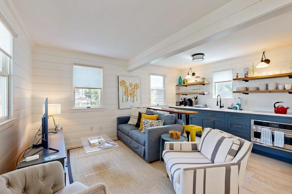 a living room with two couches and a kitchen at Long Pier Lodge in Provincetown