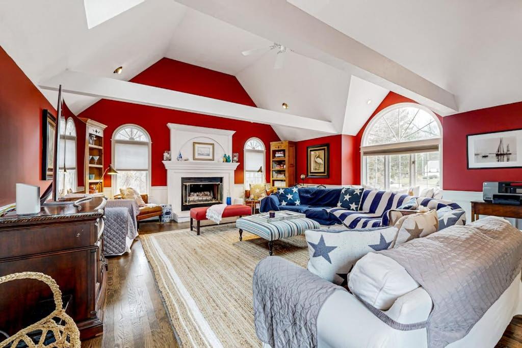 a living room with red walls and white furniture at Moon Compass Manor in Sandwich
