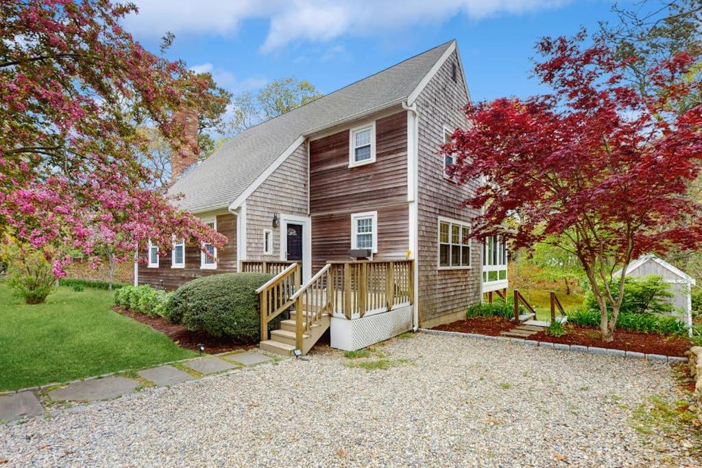 a bedroom home with a porch and a house at Cozy Charming Cottage in Brewster