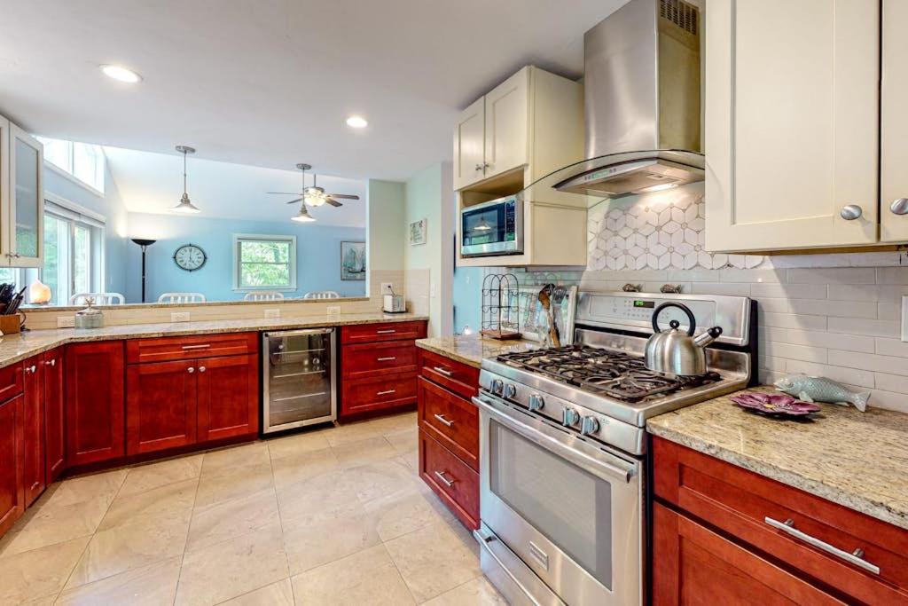 a kitchen with wooden cabinets and a stove top oven at Birch Grove in Mashpee