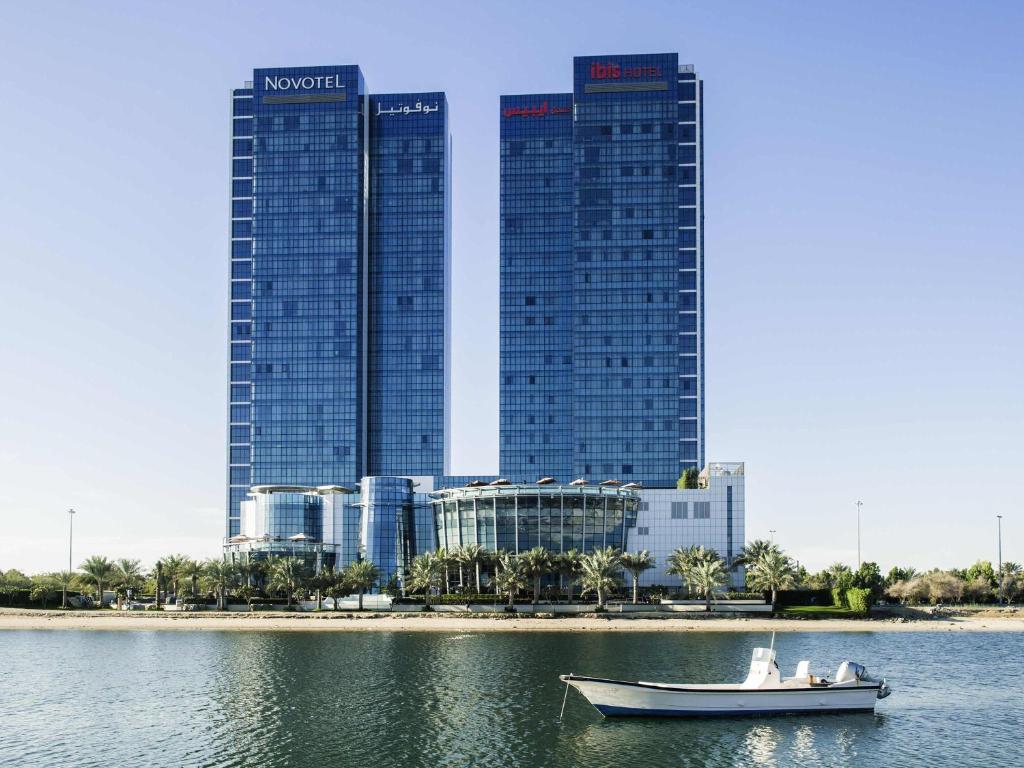 a boat in the water in front of a city at Novotel Abu Dhabi Gate in Abu Dhabi