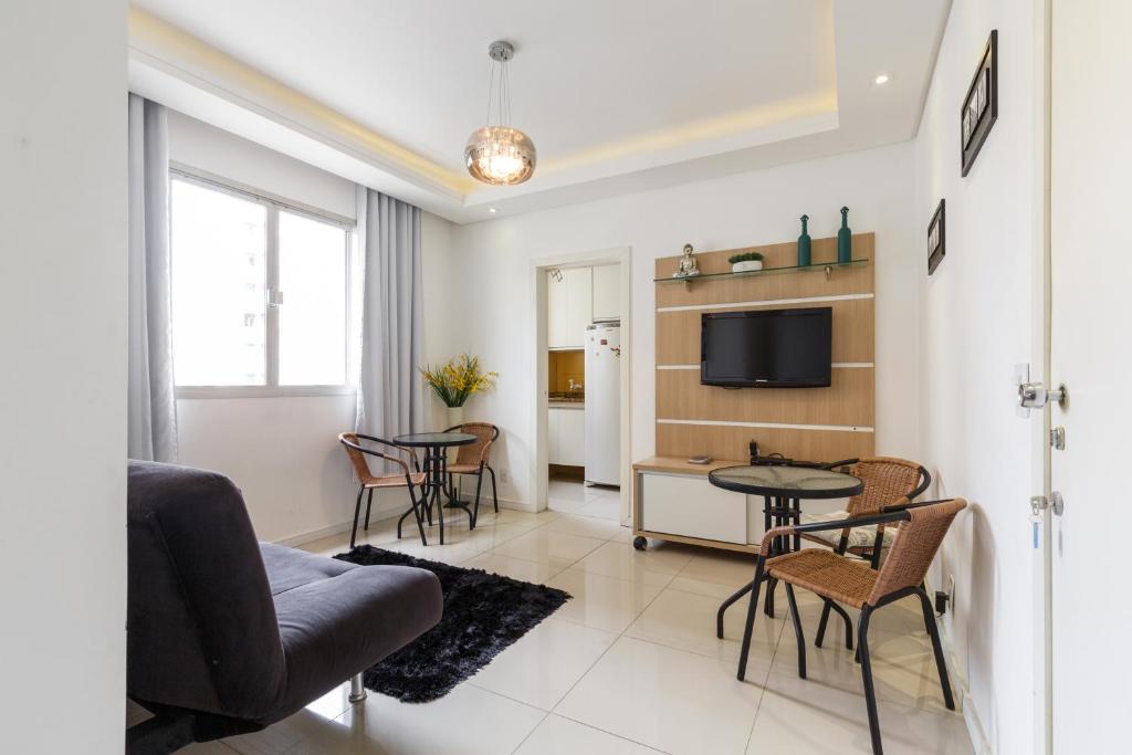 ein Wohnzimmer mit einem Sofa, einem Tisch und Stühlen in der Unterkunft Apartamento Floripa in Florianópolis