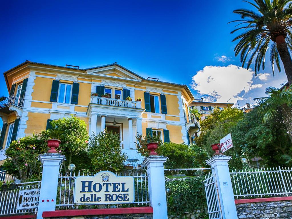 una gran casa amarilla con un cartel delante en Hotel Delle Rose en Rapallo