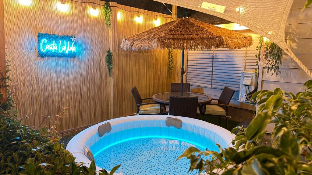 a swimming pool with a table and an umbrella at Tropical Casita LaVida in Tampa