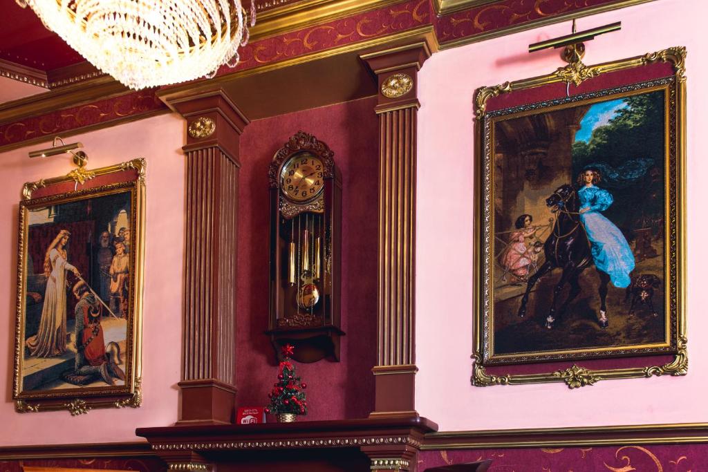 a room with paintings on the wall and a chandelier at Dvoryanskaya in Kurgan