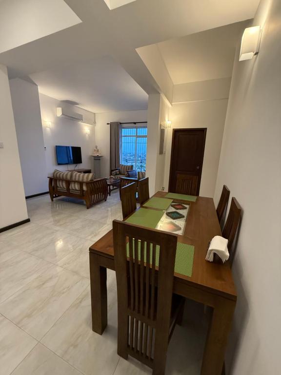 a dining room and living room with a table and chairs at Lucky homes in Maharagama