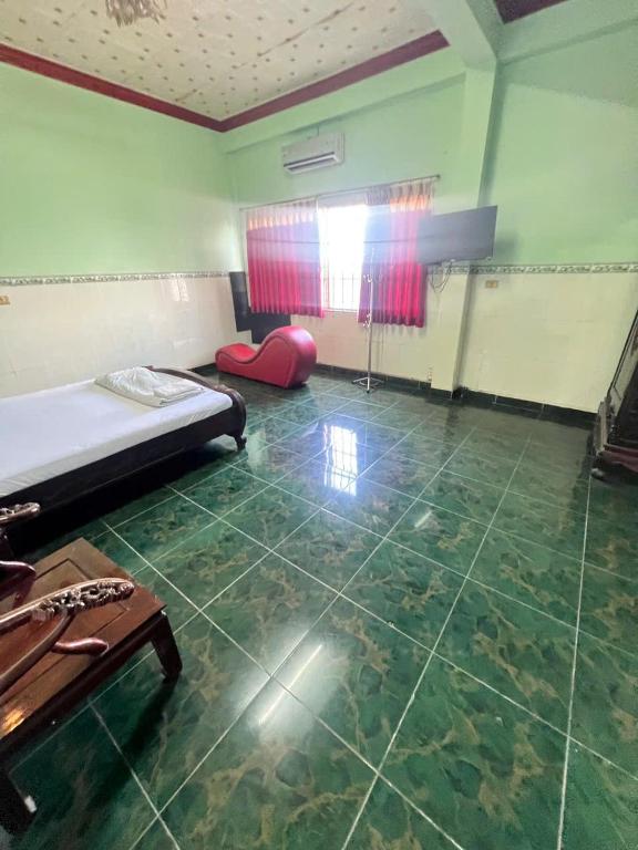 a room with a bed and a table in it at Khách Sạn Vũ Nam Hưng in Ấp Hưng Lộc