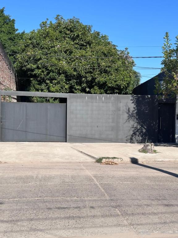 a fence with a gate in front of a building at Alojamiento Paz in Esquina