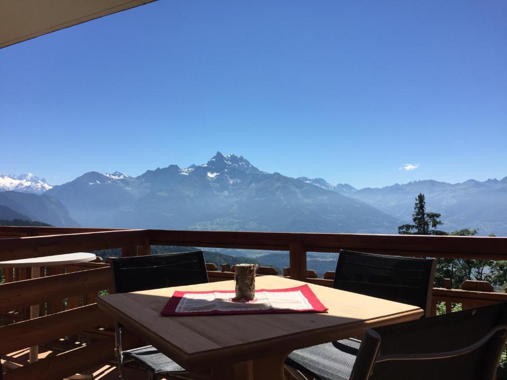 a table on a balcony with a view of mountains at Le Bristol - Villars Bristol Apartments in Villars-sur-Ollon