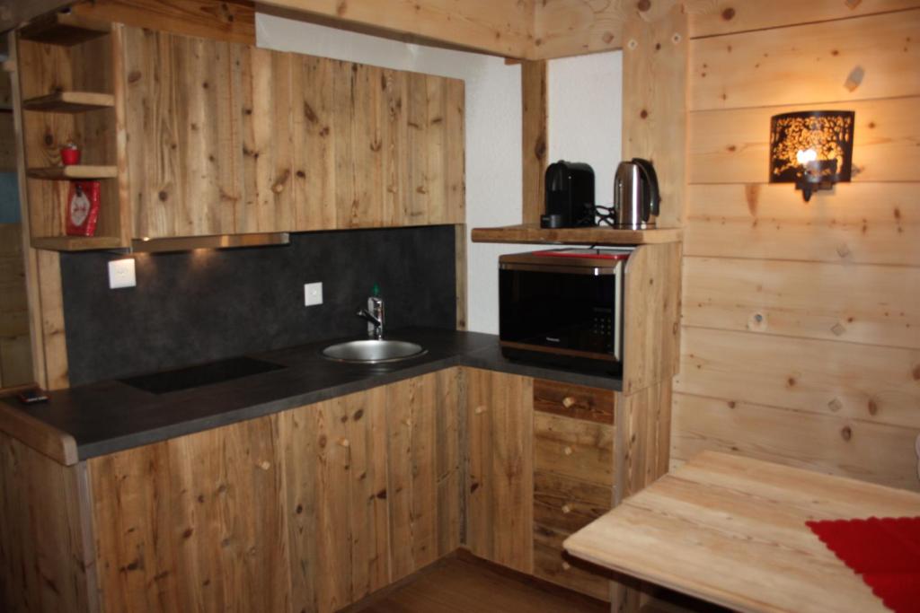 a kitchen with a sink and a microwave at Le Bristol - Villars Bristol Apartments in Villars-sur-Ollon