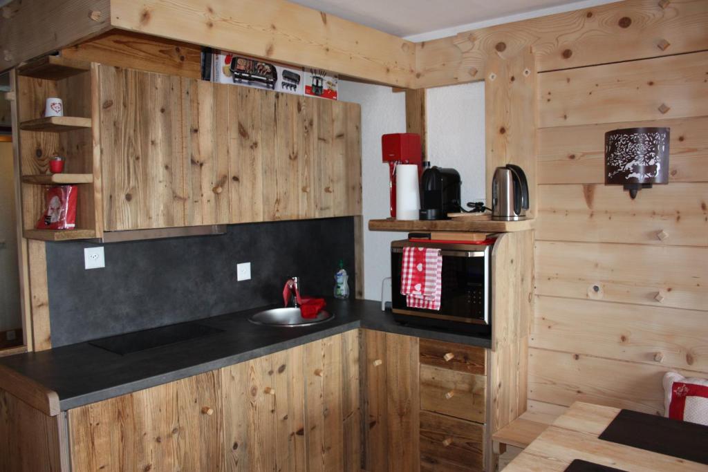 a kitchen with wooden cabinets and a black counter top at Le Bristol - Villars Bristol Apartments in Villars-sur-Ollon