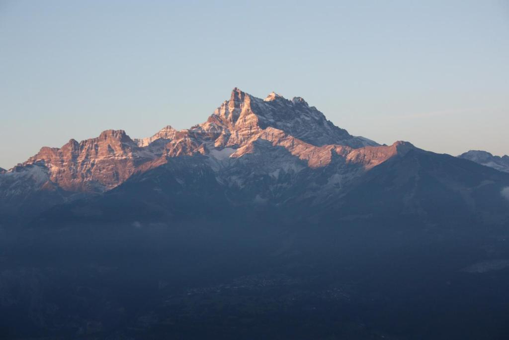 a view of a mountain with the sun shining on it at Le Bristol - Villars Bristol Apartments in Villars-sur-Ollon