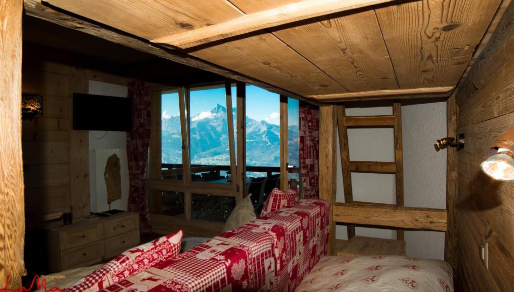 a room with a bed with a view of a mountain at Le Bristol - Villars Bristol Apartments in Villars-sur-Ollon