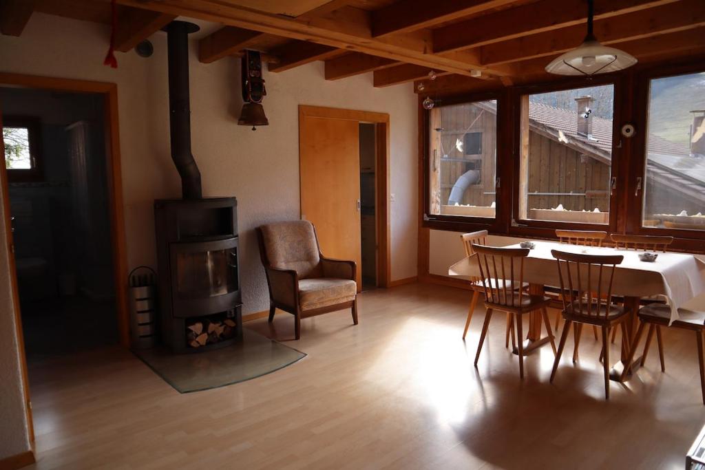 a living room with a fireplace and a table and chairs at Stöckli aux Fontaines in Tramelan