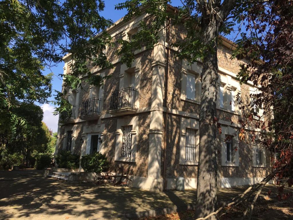 un vieux bâtiment avec des arbres devant lui dans l'établissement Villa Merenciana, à Agoncillo