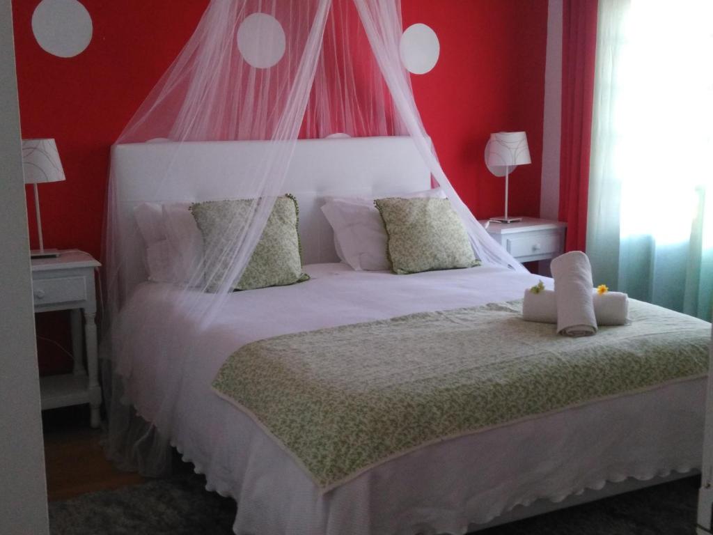 a bedroom with a white bed with a canopy at Casa da Alagoinha in Vila Nova de Milfontes