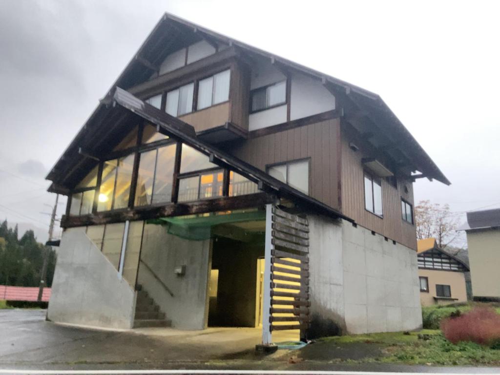 a large house with a staircase in front of it at 天水島ヒルズ in Tokamachi