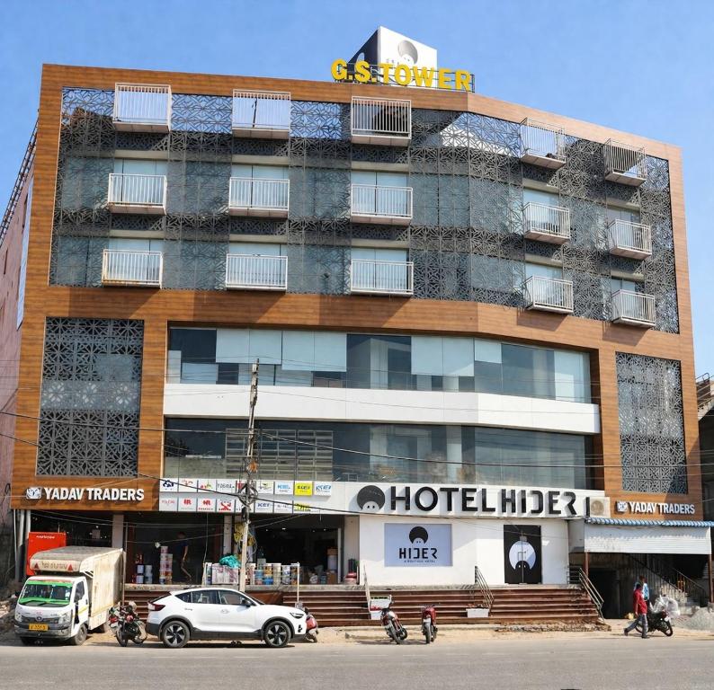 a hotel building with cars parked in front of it at Hotel Hider in Gurgaon