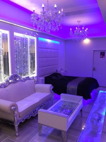 sala de estar con iluminación púrpura, sofá y cama en H-SEVEN TOYAMA (Adult Only), en Takaoka