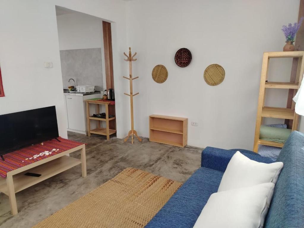 a living room with a blue couch and a tv at Cabañas Punta Negra in Punta Negra