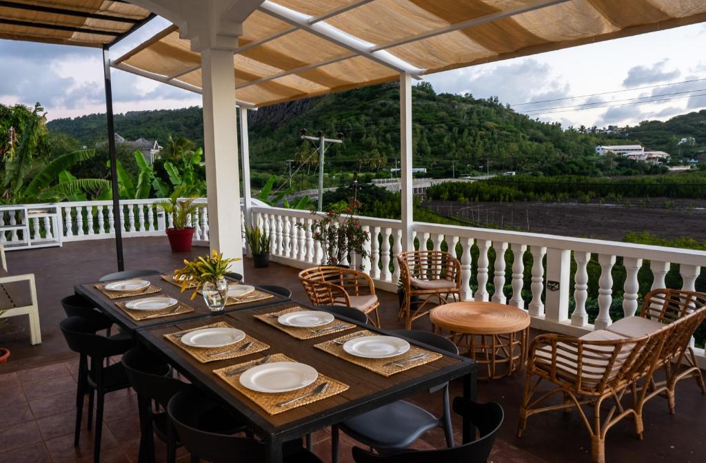 a table and chairs on a porch with a view at Les Manglier in Port Mathurin