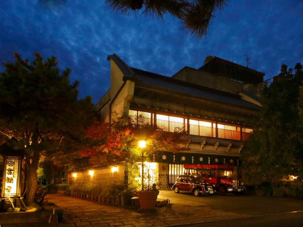 ein Gebäude mit einem Auto, das nachts davor geparkt ist in der Unterkunft Kyotoya in Takeo