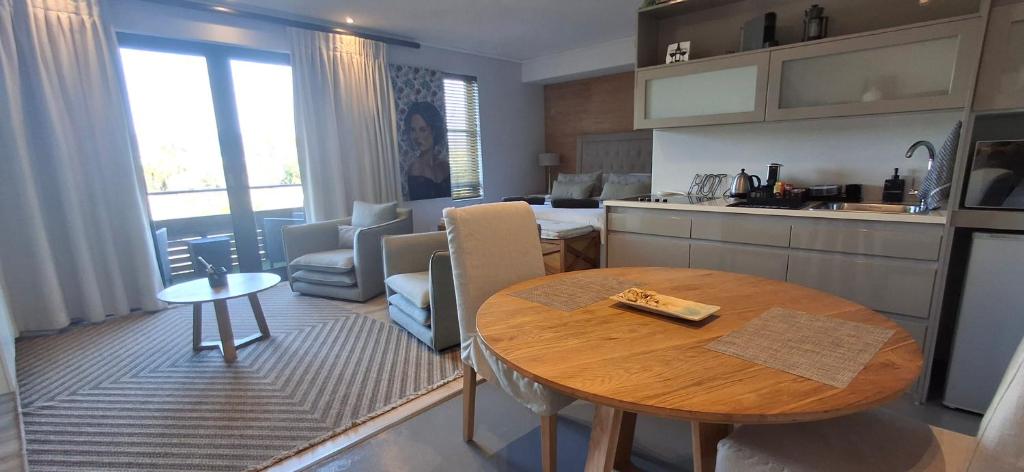 a kitchen and a living room with a table in a room at The Gallery on Gray in Knysna