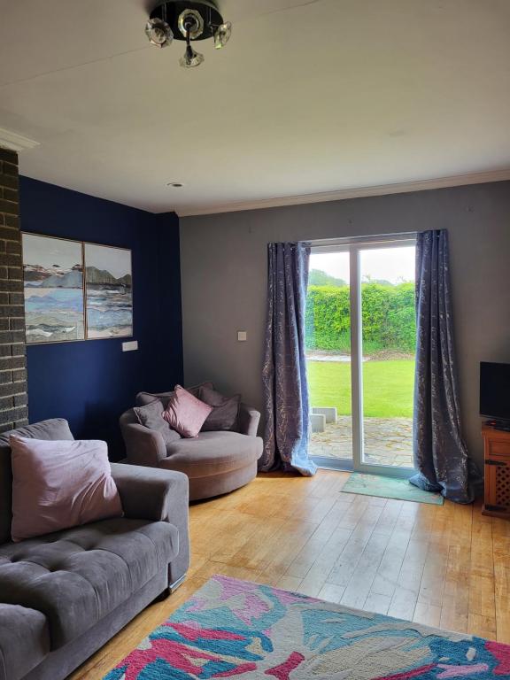 a living room with a couch and a sliding glass door at Beech lodge in Wexford