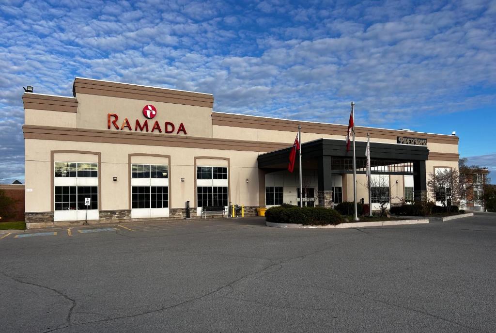 a rambala store with two flags in a parking lot at Ramada by Wyndham Trenton in Trenton