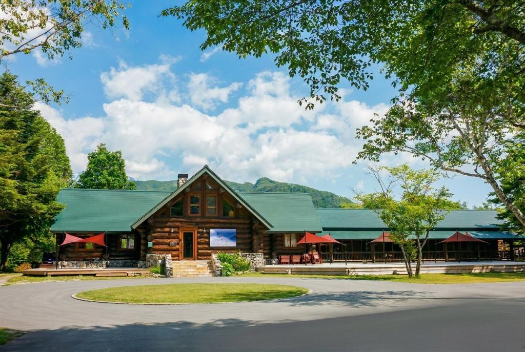 a log cabin building with a green roof at Reposer Hakuba Hotel and Offsite Villa in Hakuba
