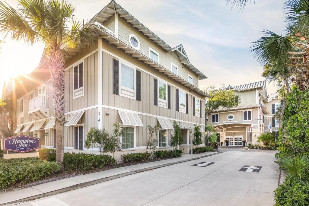 a house with palm trees in front of it at Hampton Inn New Smyrna Beach in New Smyrna Beach