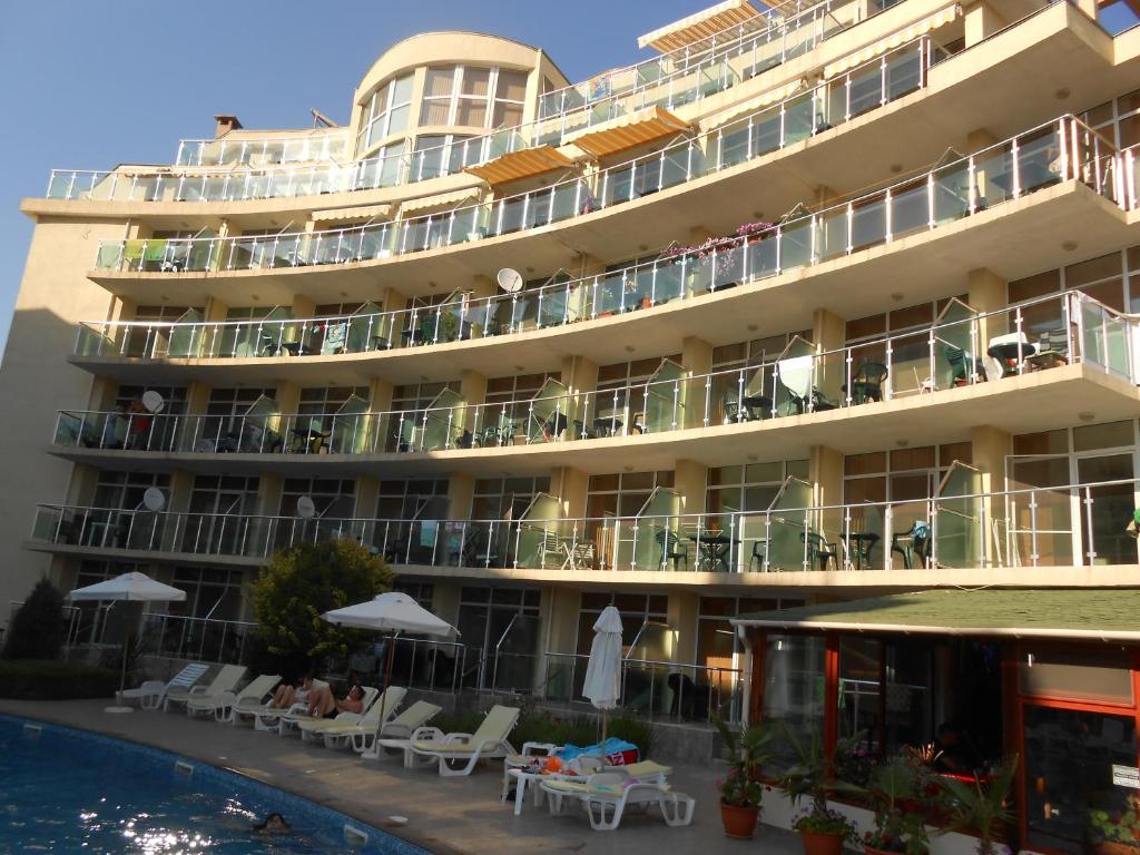 un hotel con piscina frente a él en Sunny Holiday Apartments, en Sunny Beach