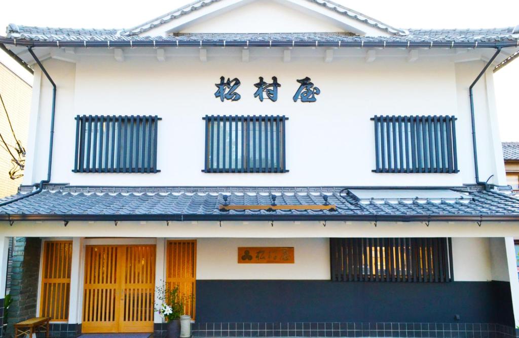 川越的住宿－松村屋日式旅館，建筑的侧面有亚洲文字