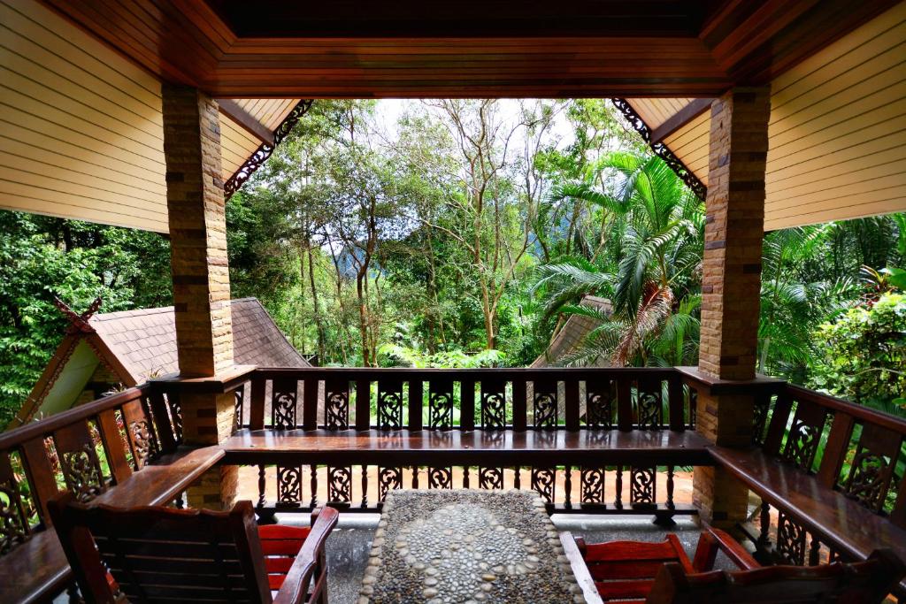 a porch of a resort with a table and chairs at Khao Sok Las Orquideas Resort in Khao Sok