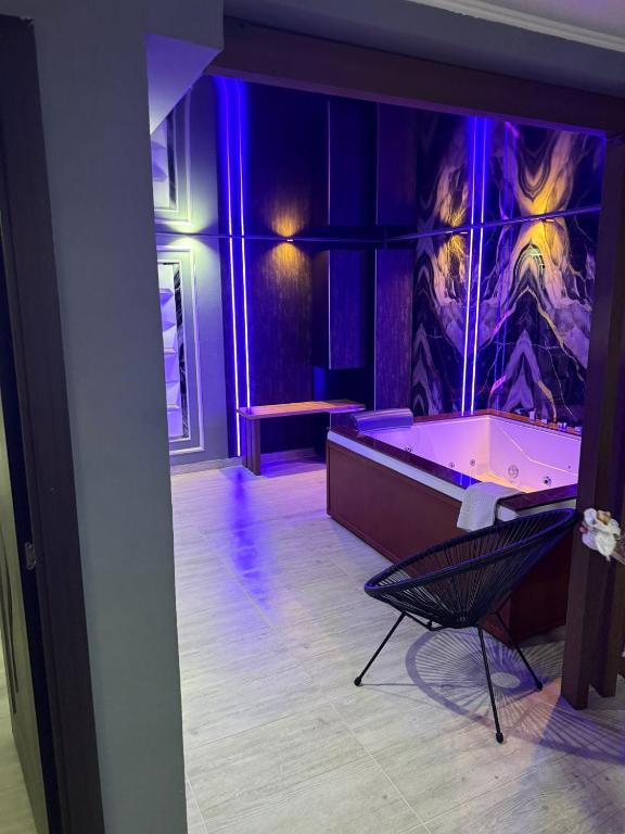 a room with a tub and a chair in it at Regim Hotel Hanea jacuzzi in camera,piscina exterioara si sauna comuna in Sibiu