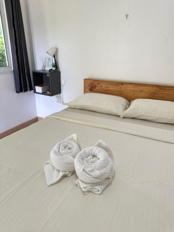two towels on a bed in a bedroom at โรงแรมซุนเซนโฮมแอนด์คาเฟ่ in Ban Na Lao