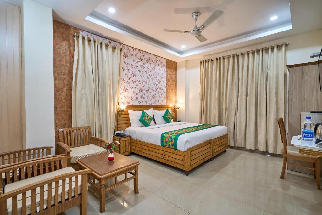 a bedroom with a bed and a couch and a table at Treebo Roshan House Near Mcleodganj in McLeod Ganj