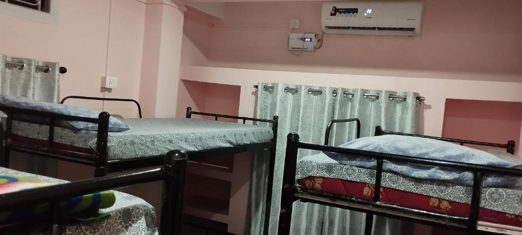 two bunk beds in a room with curtains at Backpackers' Haven in Guwahati