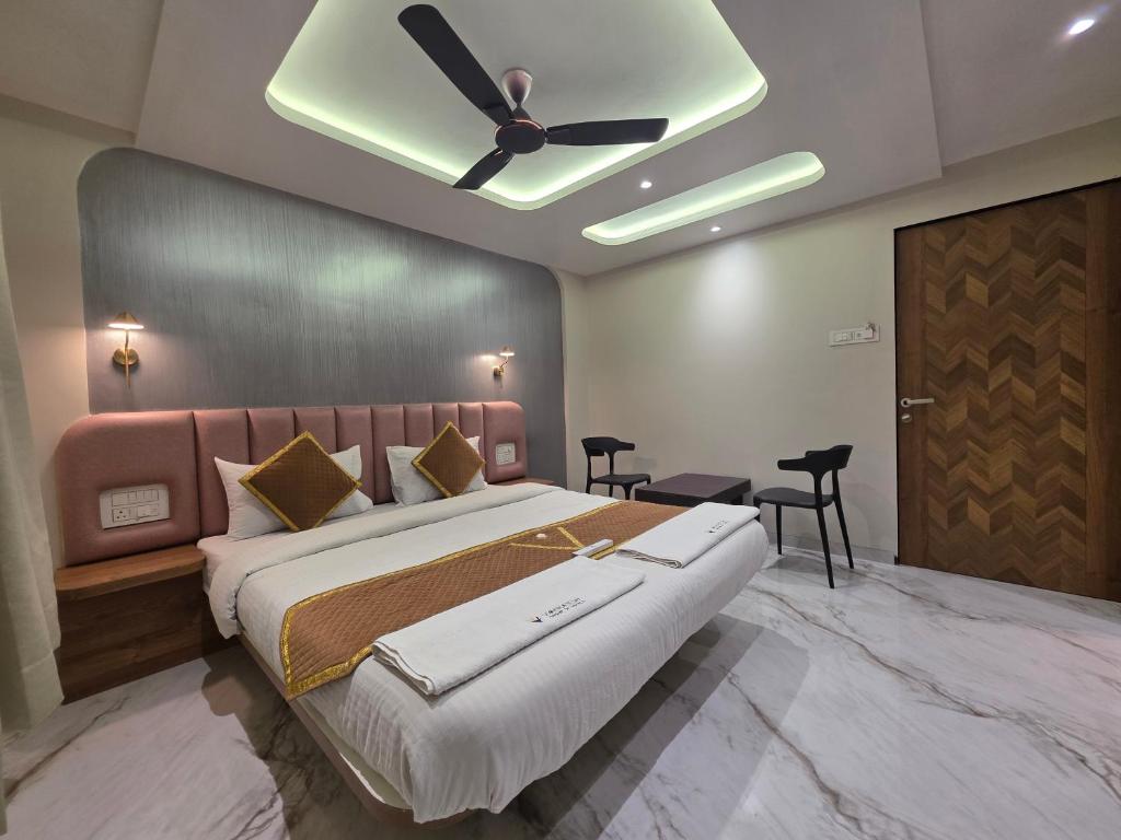a bedroom with a large bed with a ceiling fan at New Vyankatesh in Mahabaleshwar