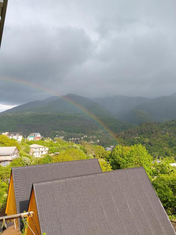 a rainbow over a house with a mountain in the background at Taqnvac hrashq in Dilijan