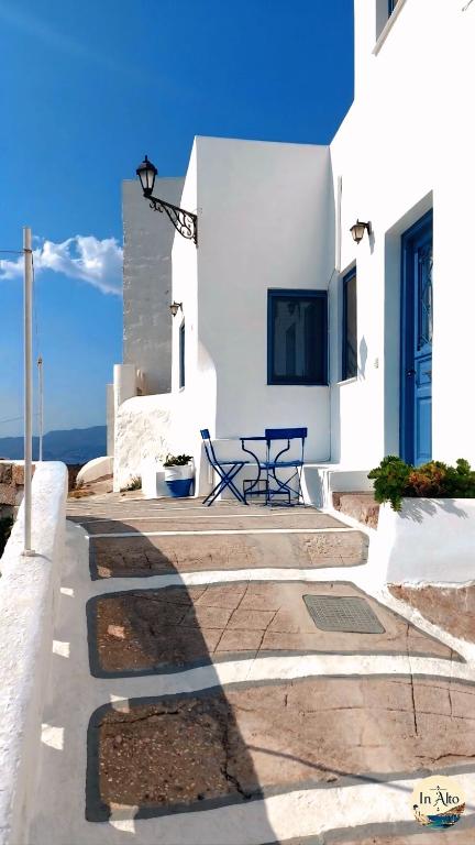 a patio with a table in front of a white building at In Alto in Plaka Milou