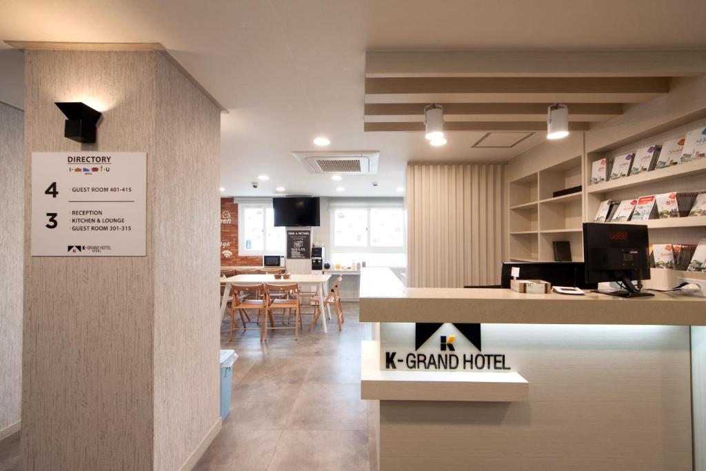 Cette chambre comprend un comptoir et une table avec des chaises. dans l'établissement K-Grand Hotel Seoul, à Séoul