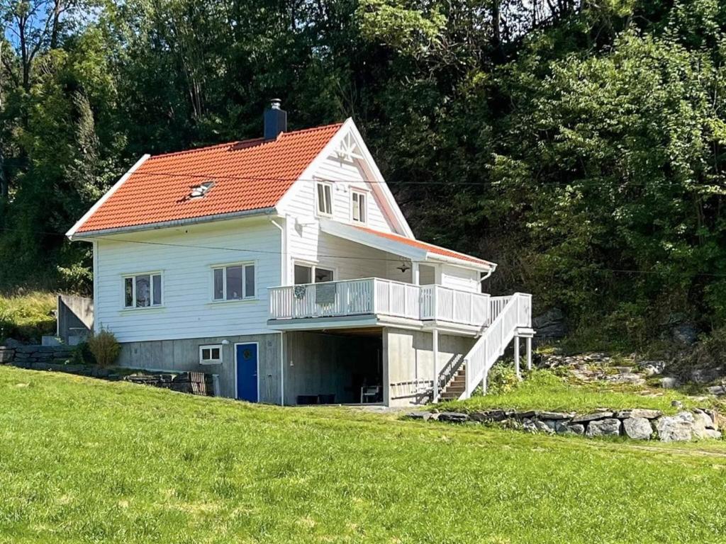 a white house with an orange roof on a hill at 6 person holiday home in Bjoa-By Traum in Utbjoa