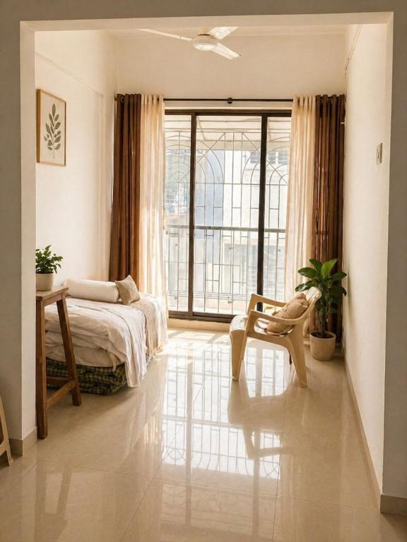 a bedroom with a bed and a large window at Sk Holiday Apartment in Alibaug