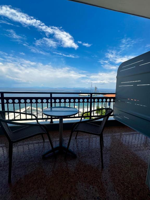 a table and chairs on a balcony with a view of the ocean at KAMVISSIS HOTEL in Tyros