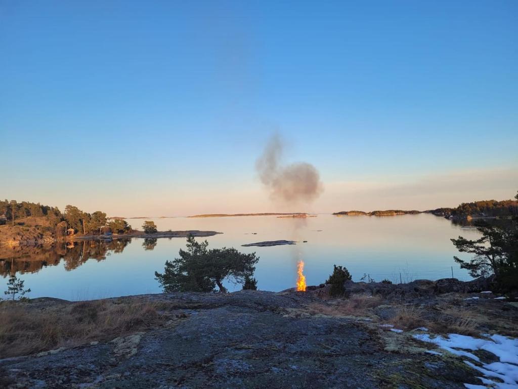 a fire is burning in the middle of a lake at Lillstugan at Sävö in Västerljung