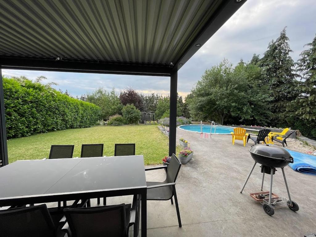 a patio with a table and chairs and a swimming pool at Maison avec piscine à Dinant in Sorinnes