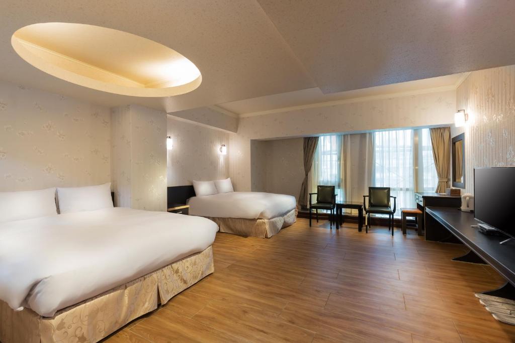 a hotel room with two beds and a television at Lishin Hotel in Hualien City