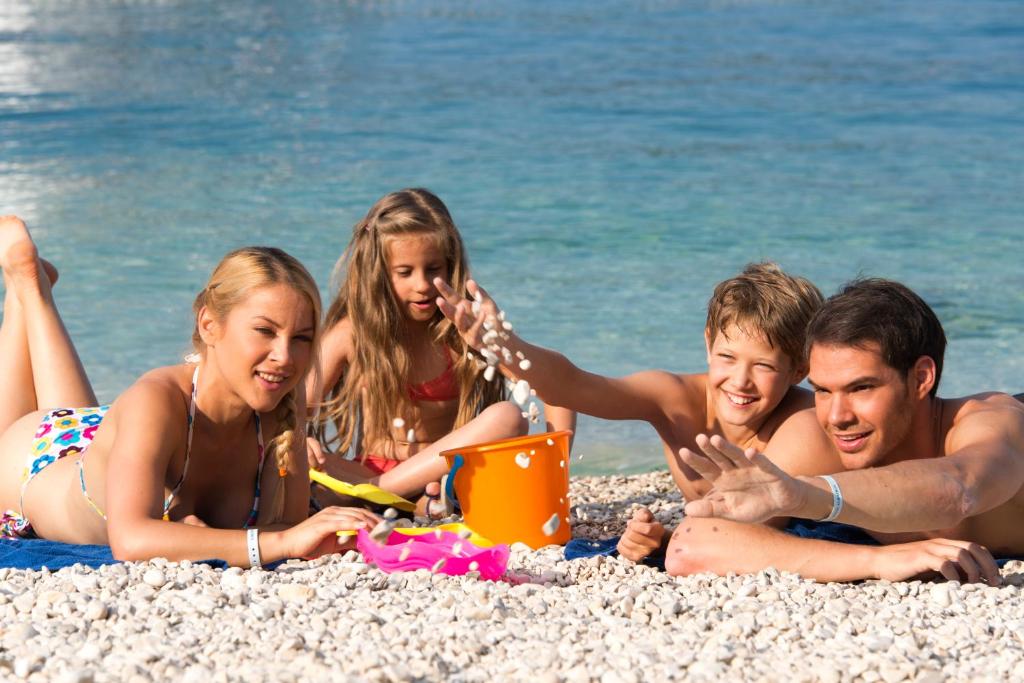 a group of people laying on the beach at Hotel Istra Plava Laguna in Poreč
